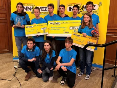 Un groupe de jeunes lauréates et lauréats, portant des t-shirts bleus, pose devant un fond jaune « Science & Vie Junior – Innovez ». Elles et ils tiennent des chèques de prix allant de 500 à 1 200 euros ainsi que des trophées 