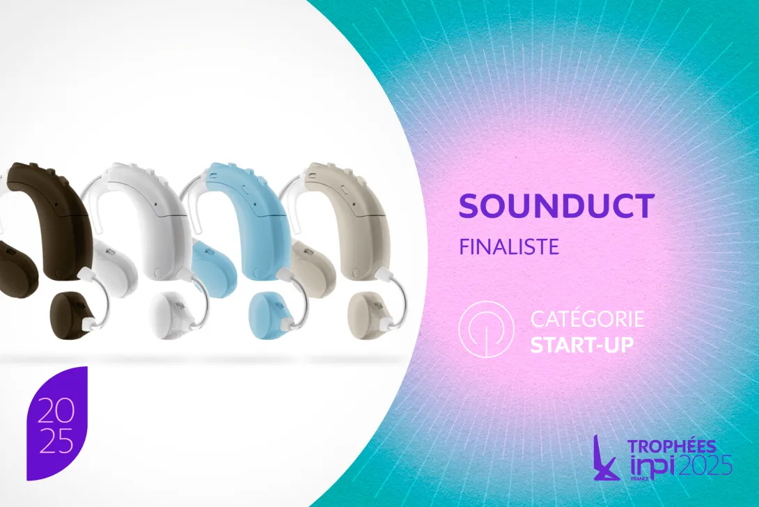 Une rangée d’appareils auditifs contour d’oreille Sounduct. Il existe cinq couleurs différentes : noir, blanc, bleu clair, beige et une autre nuance de bleu clair. Sur le côté droit, on peut lire "SOUNDUCT" en grand, suivi de "FINALISTE".