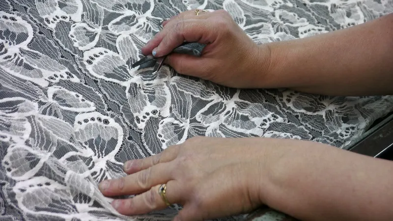 La visiteuse inspecte la dentelle © E Breitbart